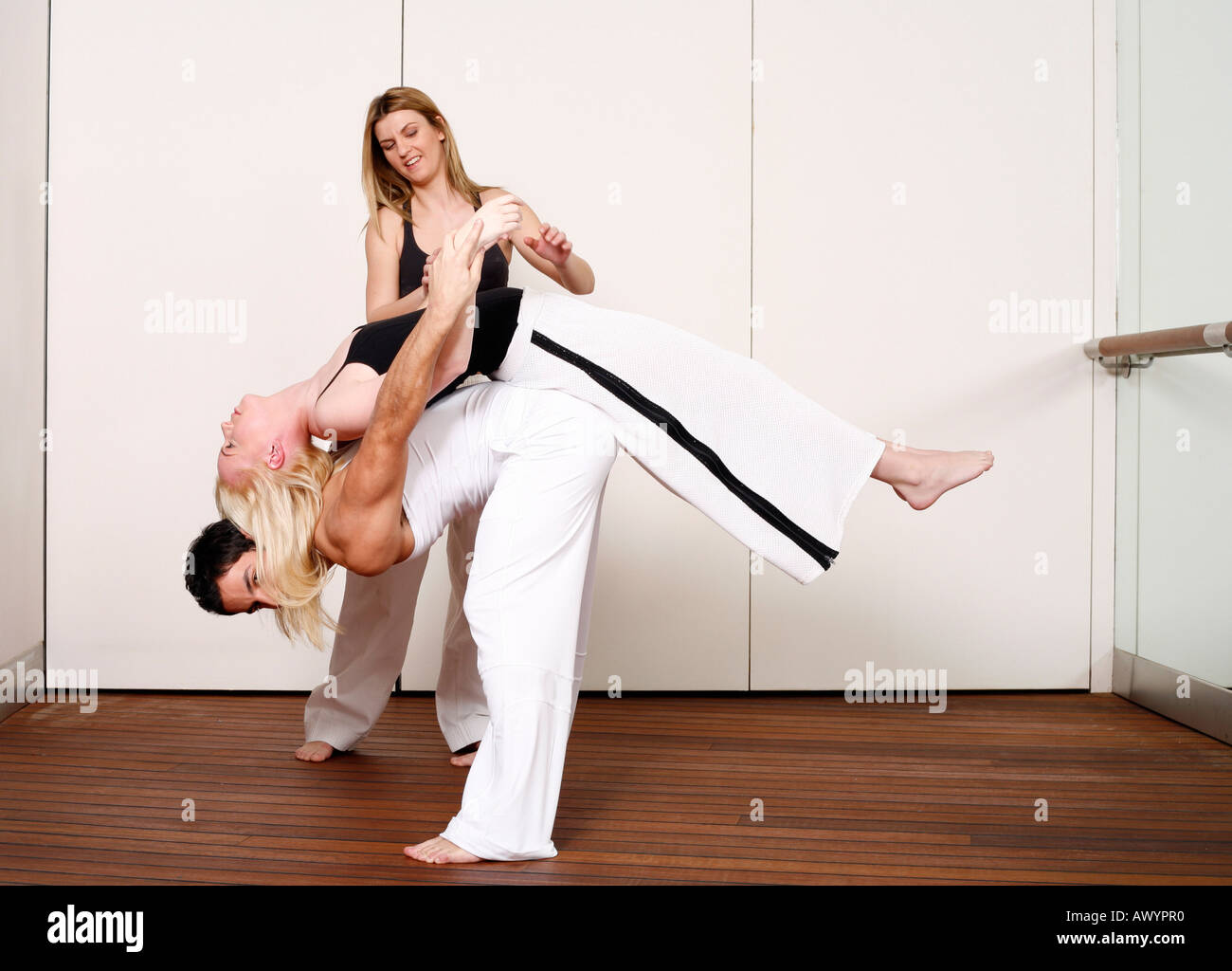 Partners practicing flexibility in yoga and Capoeira programs Stock Photo