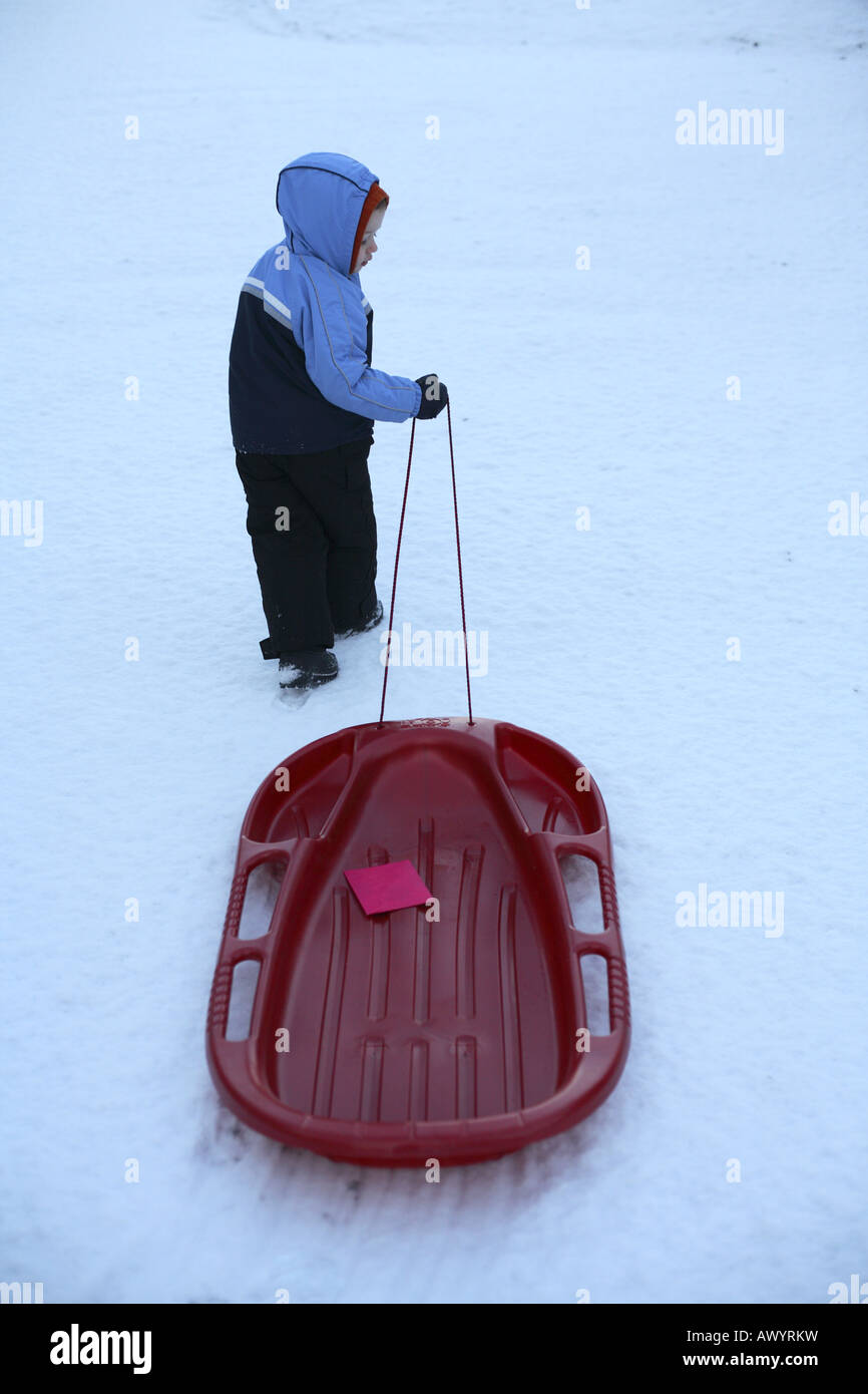 Young boy pulling a sled with card on it Stock Photo