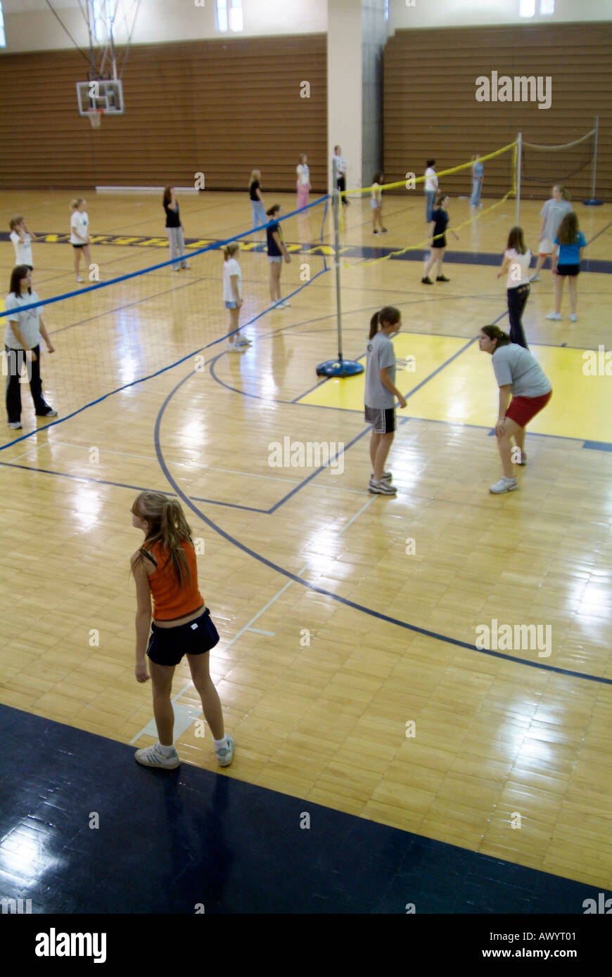 High school student females participate in a physical education volleyball class in a gymnasium Stock Photo