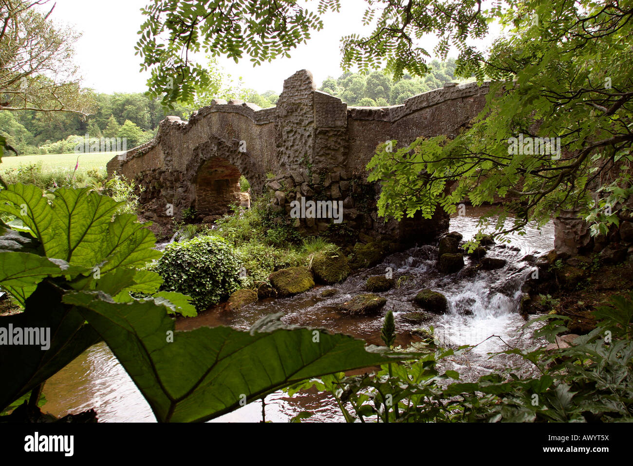 UK, Somerset Dunster Castle garden bridge over River Avill Stock Photo