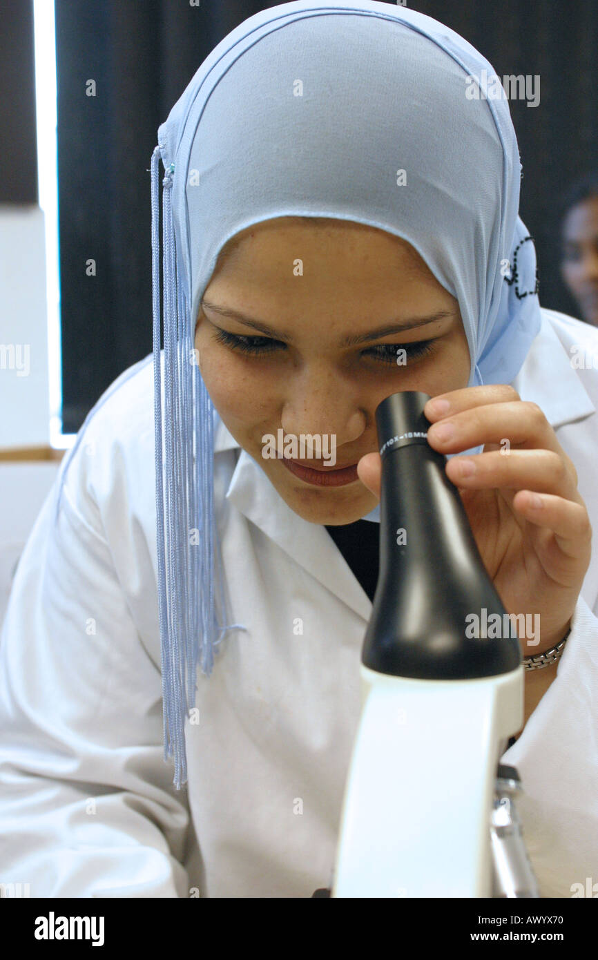Female Sixth form Student looking through microscope in science lab ...