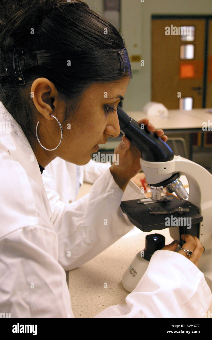 Female Sixth form Student looking through microscope in science lab ...