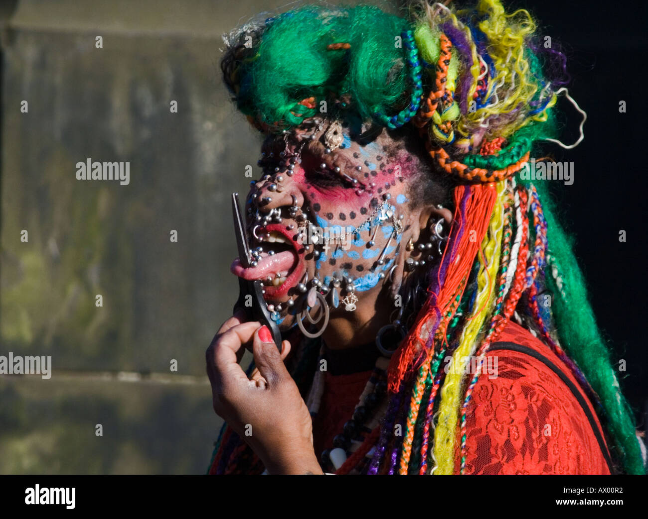 The world's most pierced woman at the Edinburgh festival fringe inserts a pair of scissors through her tongue, Scotland. Stock Photo