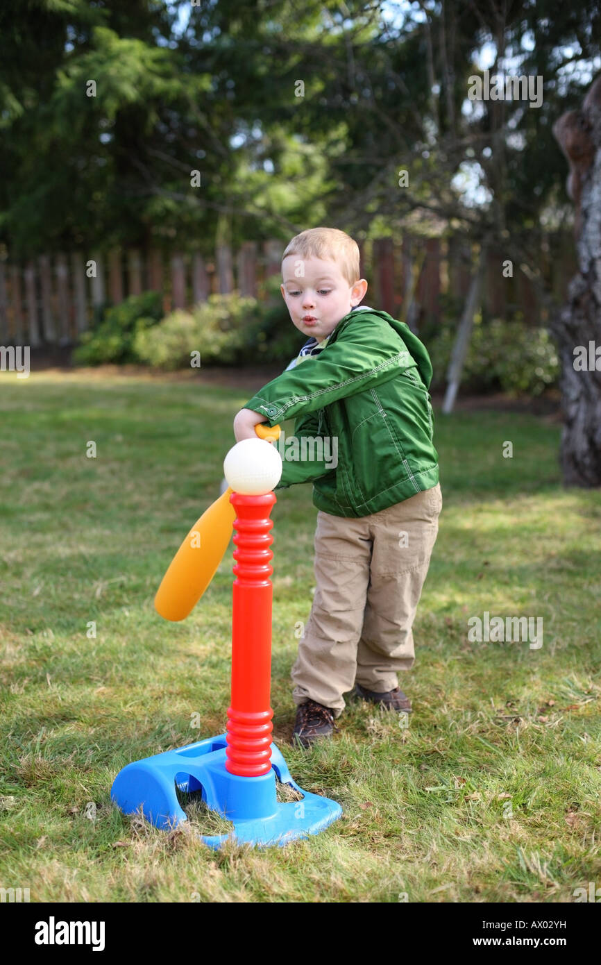 Young boy hitting baseball off tee Stock Photo