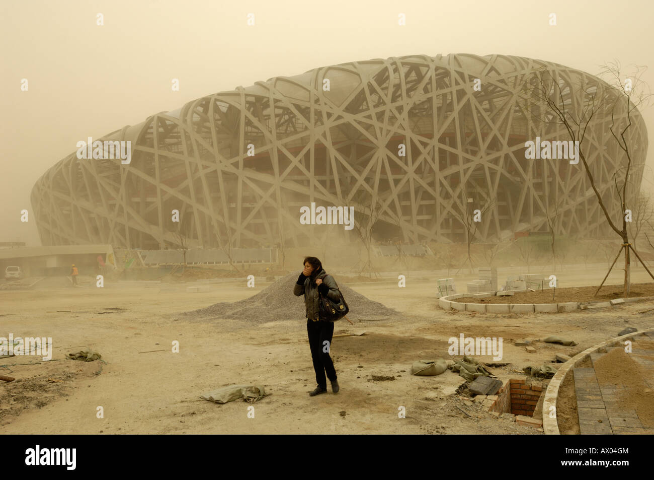 Lady covers her face with hand amid severe sandstorm in construction site of National Stadium for Beijing Olympics.18-Mar-2008 Stock Photo