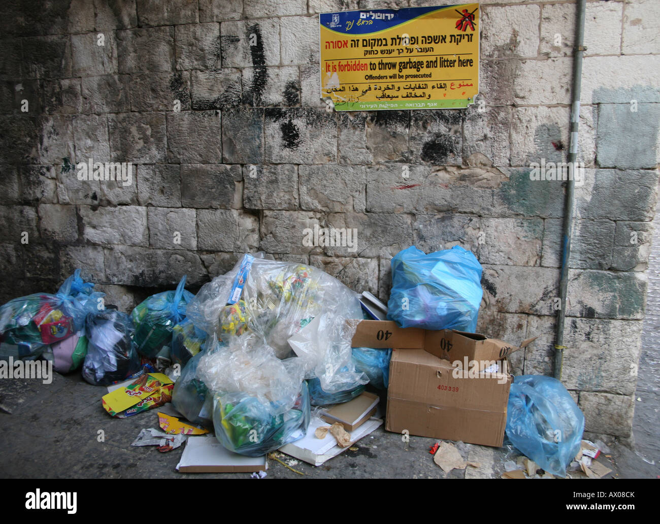 Garbage strewn under a sign forbidding it in a market in the old city section of Jerusalem Stock Photo