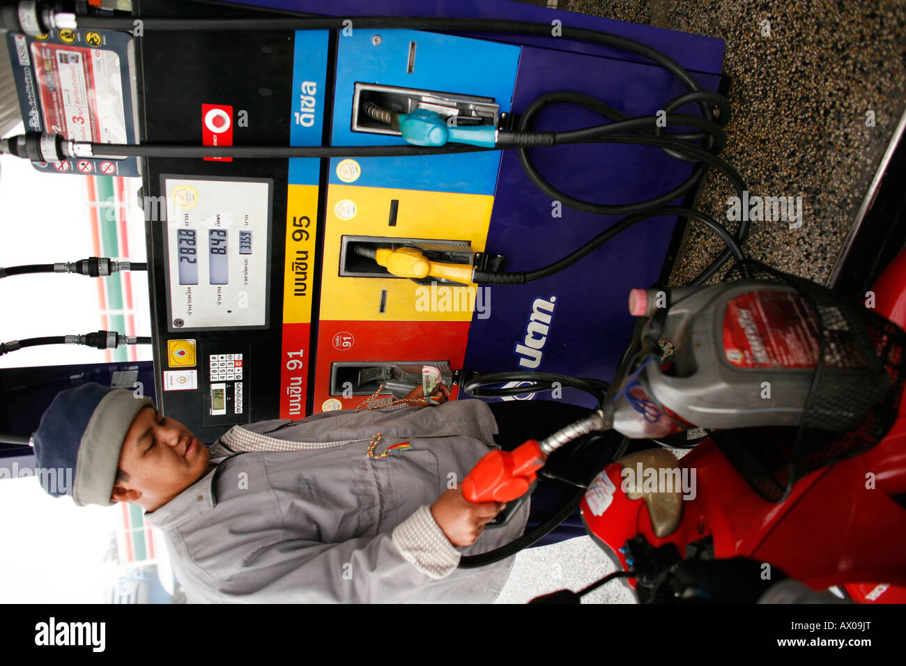 A service station attendant in Bangkok fills a jerry can with petrol Stock Photo