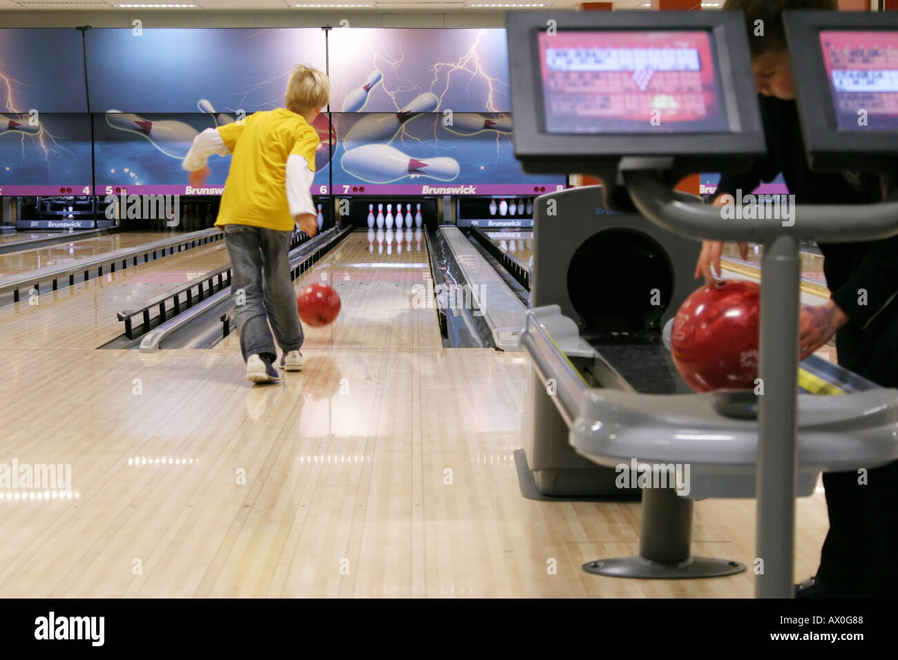 8-year old child bowling in a bowling alley Stock Photo