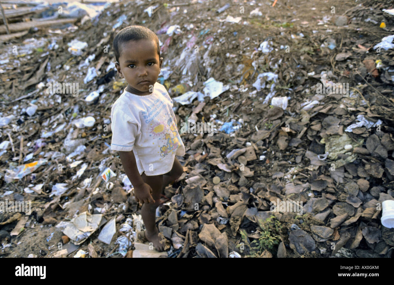 Street child rummaging through a garbage dump, Mahabalipuram, Tamil Nadu, India, Asia Stock Photo
