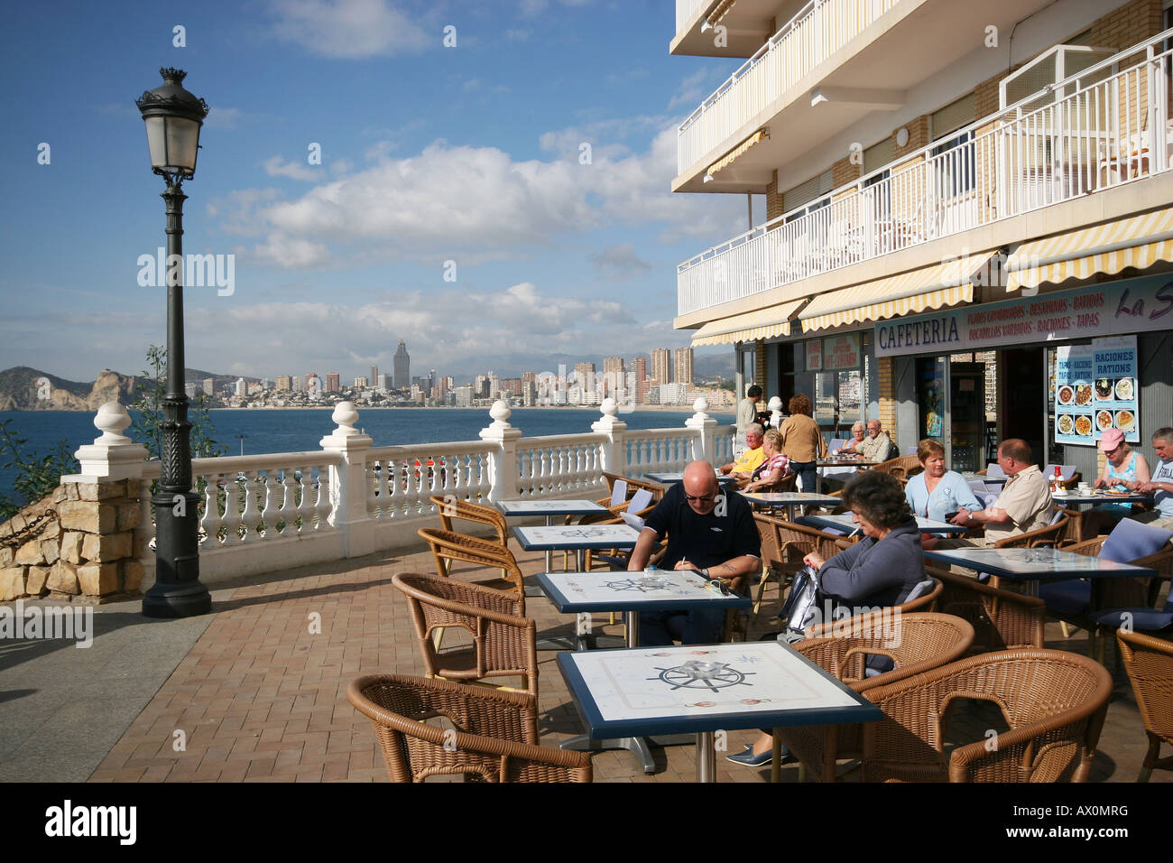 Wide angle lens shot of people sitting outside a pavement cafe in Benidorm, Spain. Stock Photo