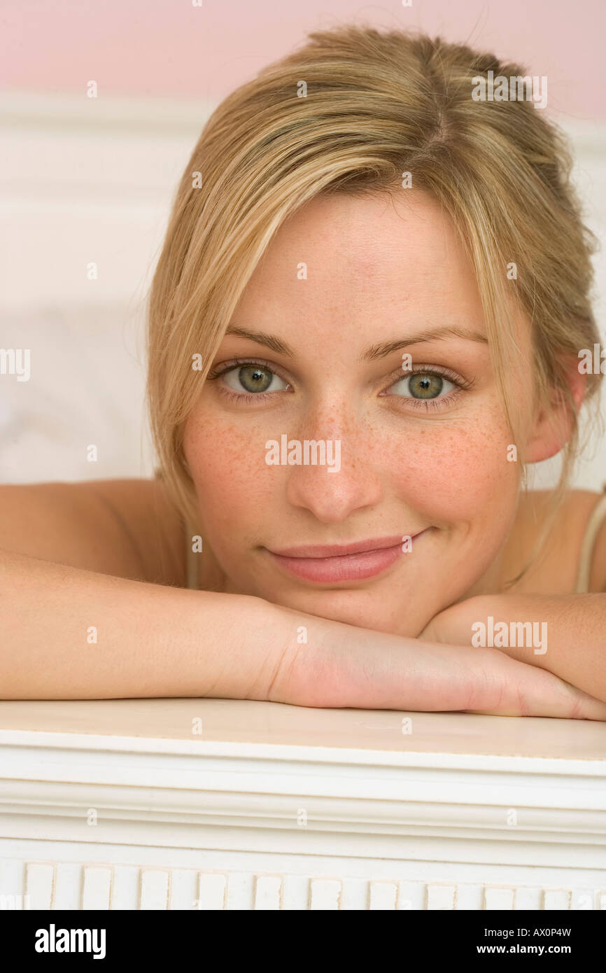 Woman lying on the edge of a bed, looking at camera Stock Photo Alamy