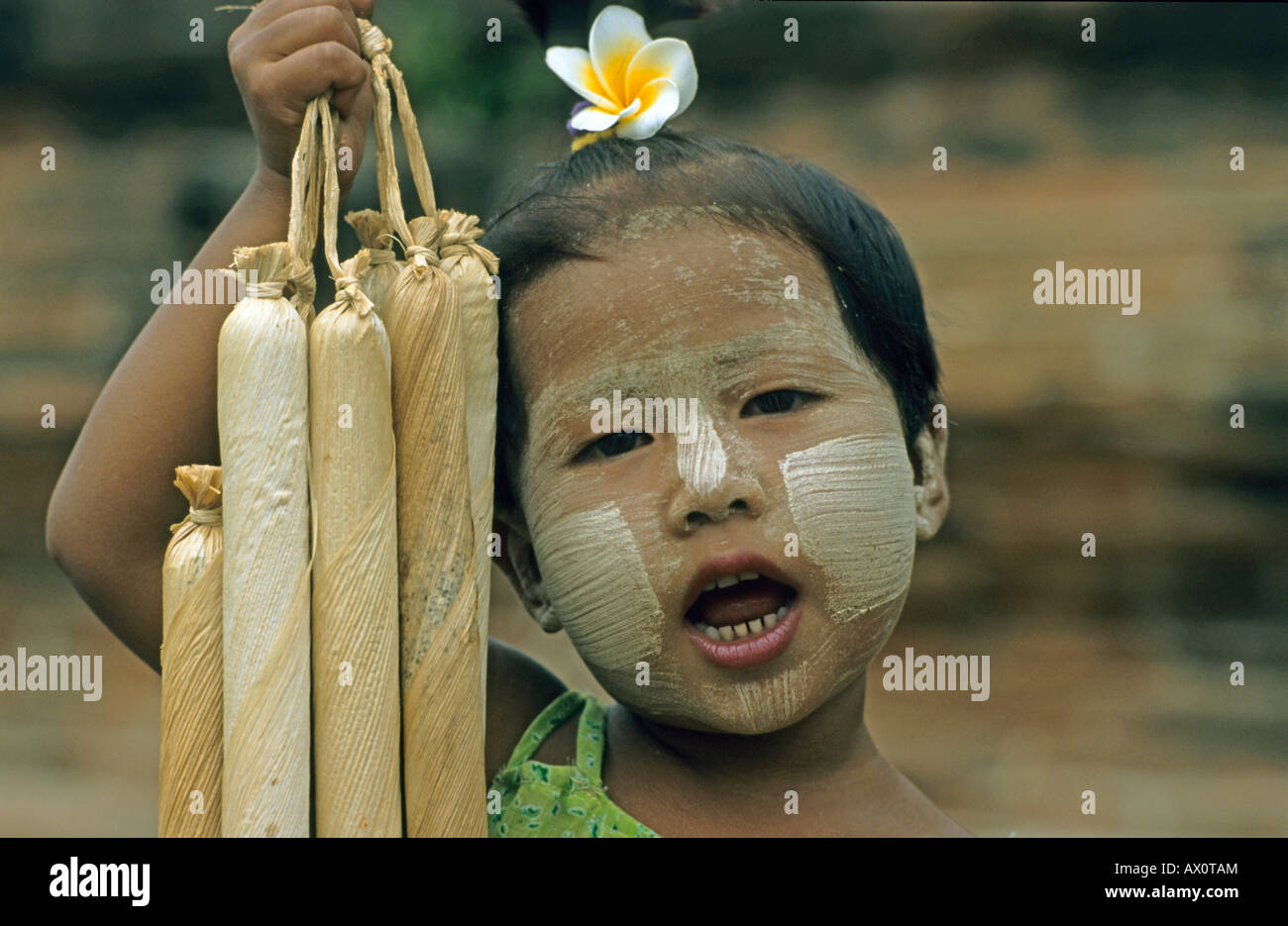 Girl with her face painted in the traditional Tanaka style selling cherrots, Myanmar (Burma), Southeast Asia Stock Photo