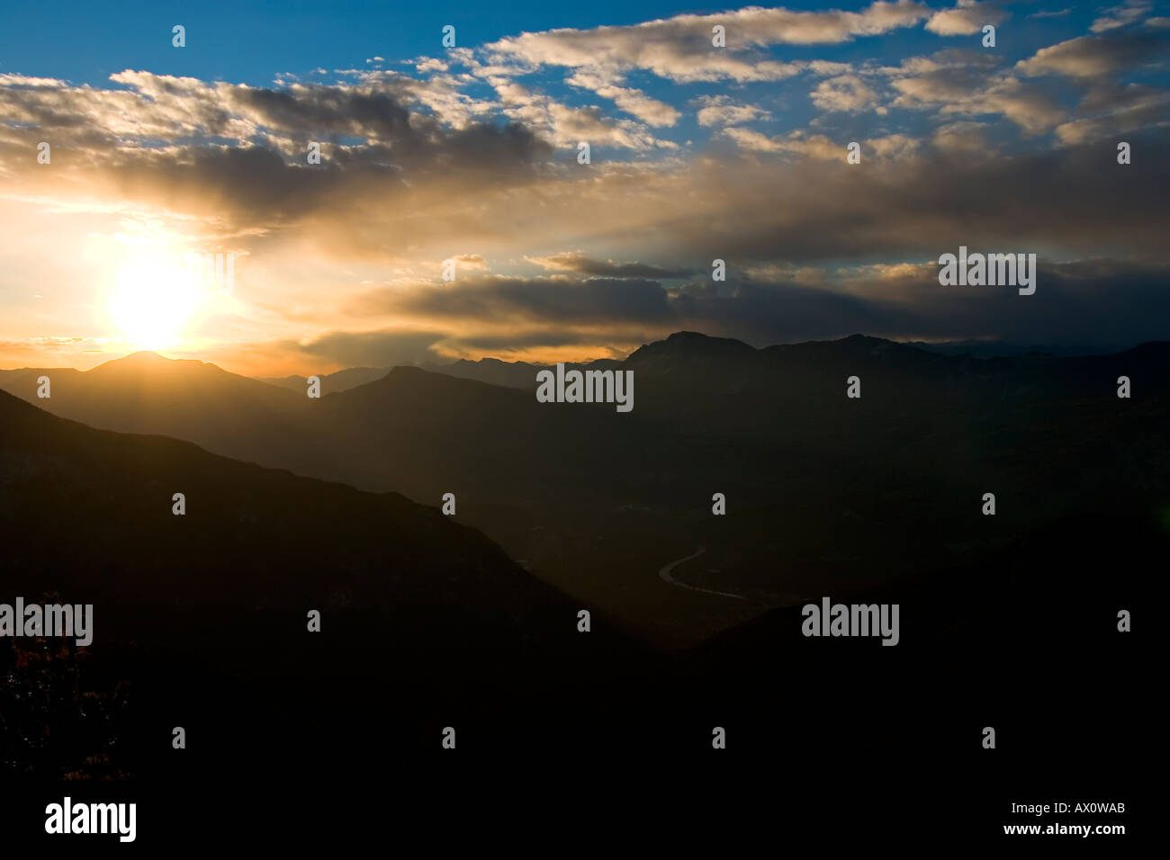 Panorama with mountains sun clouds and smooth blue sky Stock Photo