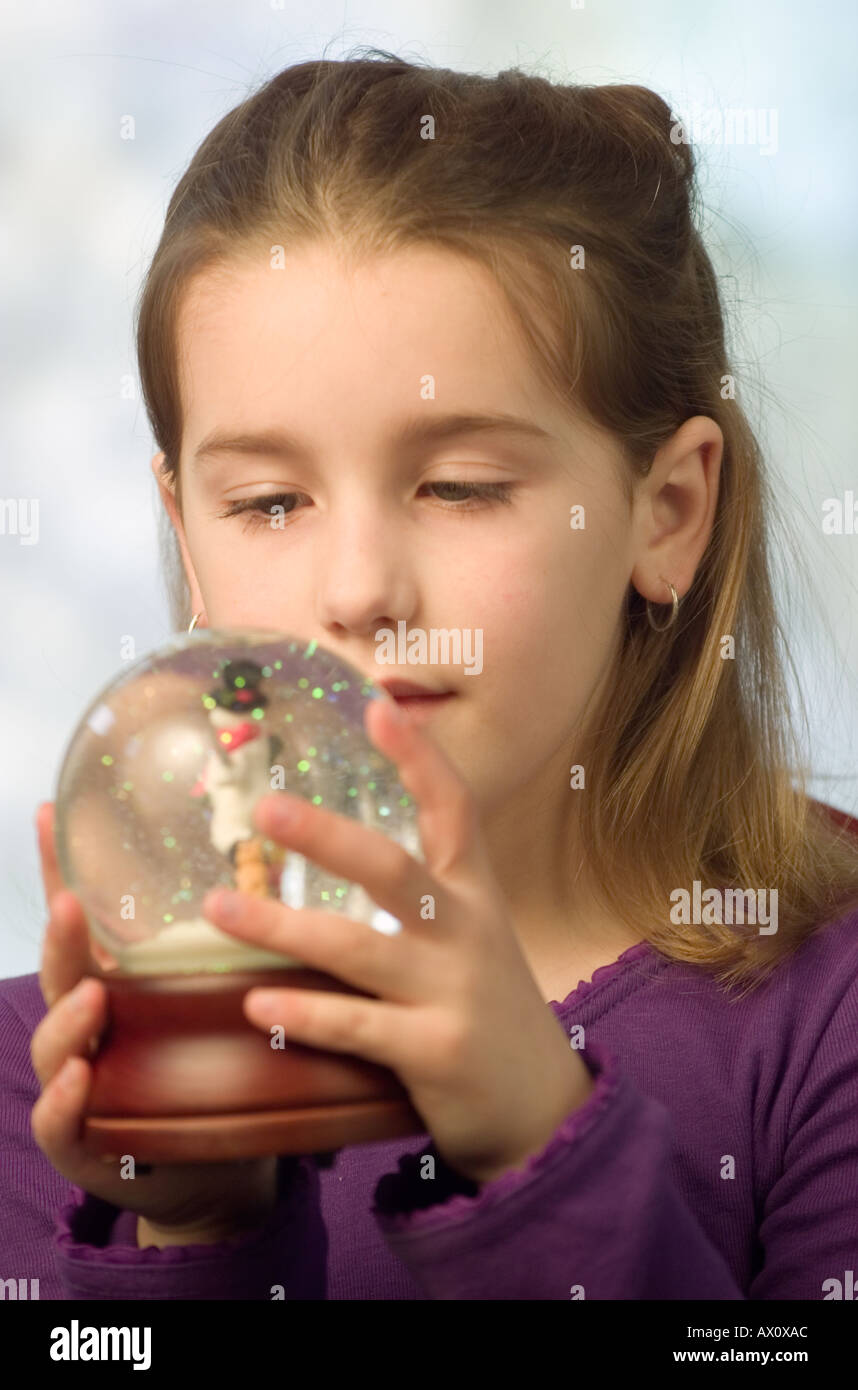 Portrait Caucasian girl shaking snow globe Stock Photo Alamy