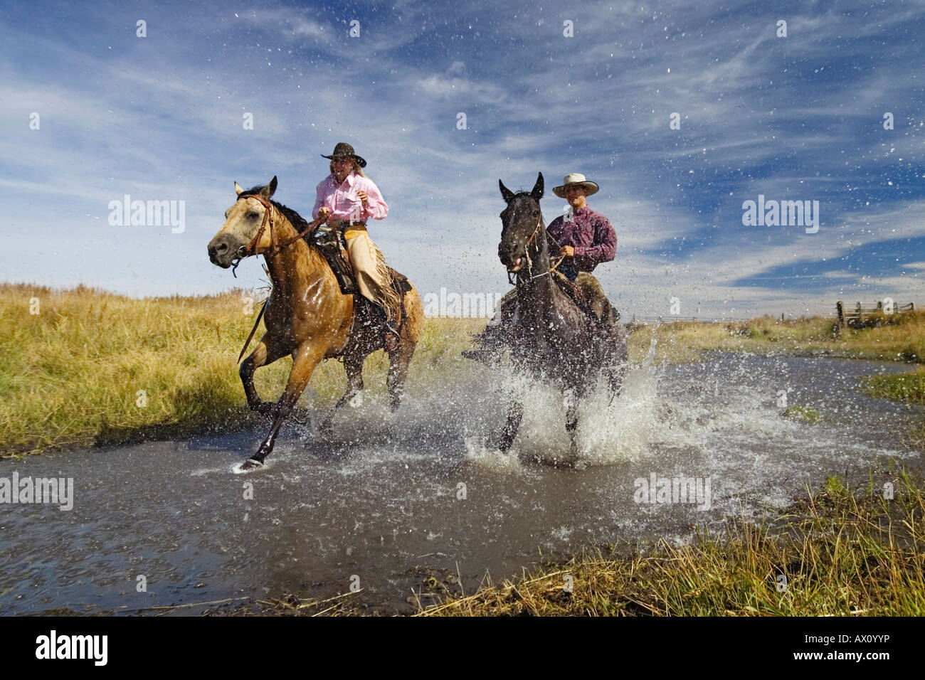 Cowboy and cowgirl riding in water wildwest, Oregon USA Stock Photo
