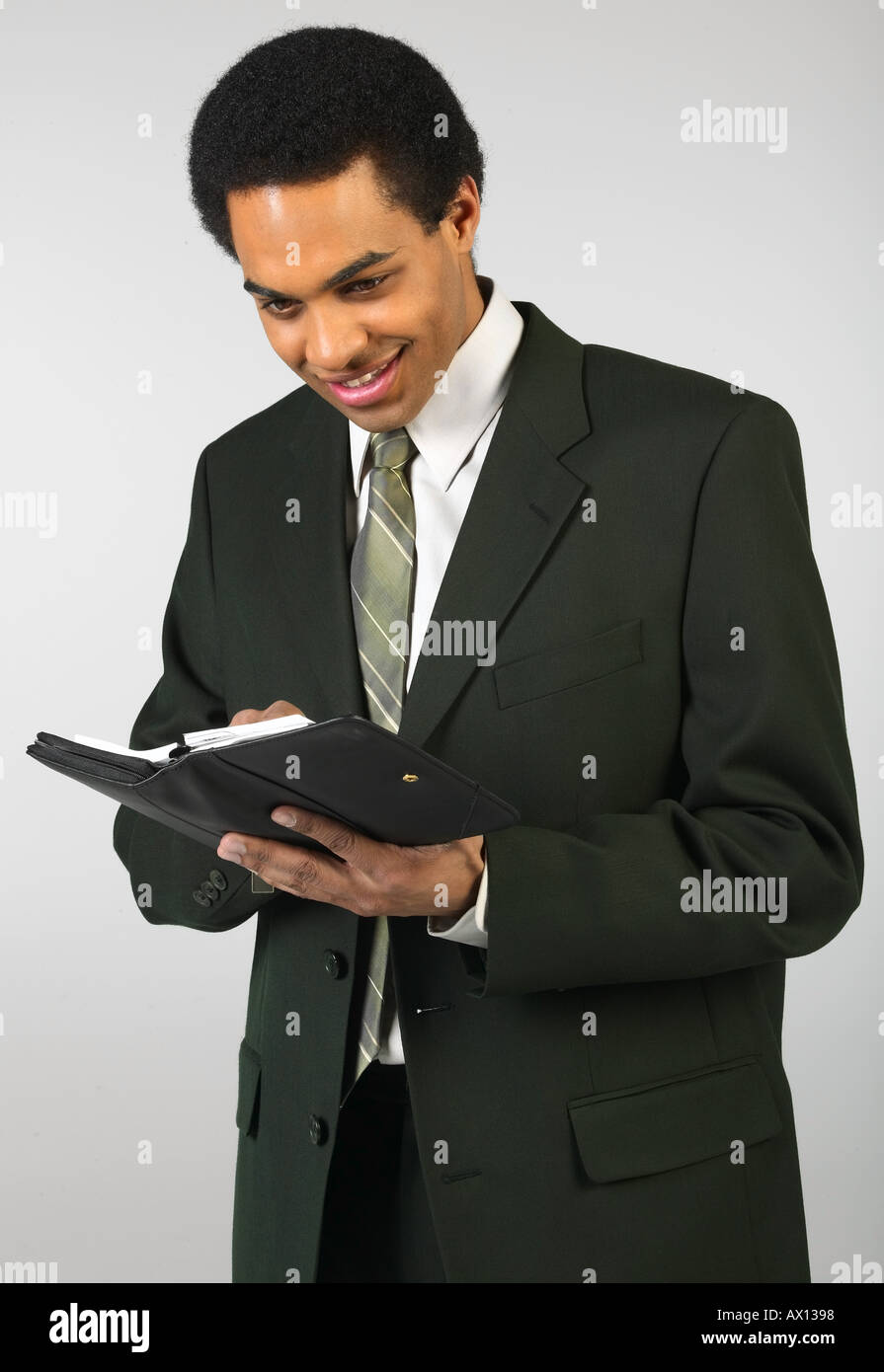 Smiling businessman writing in day planner uid 1459710 Stock Photo