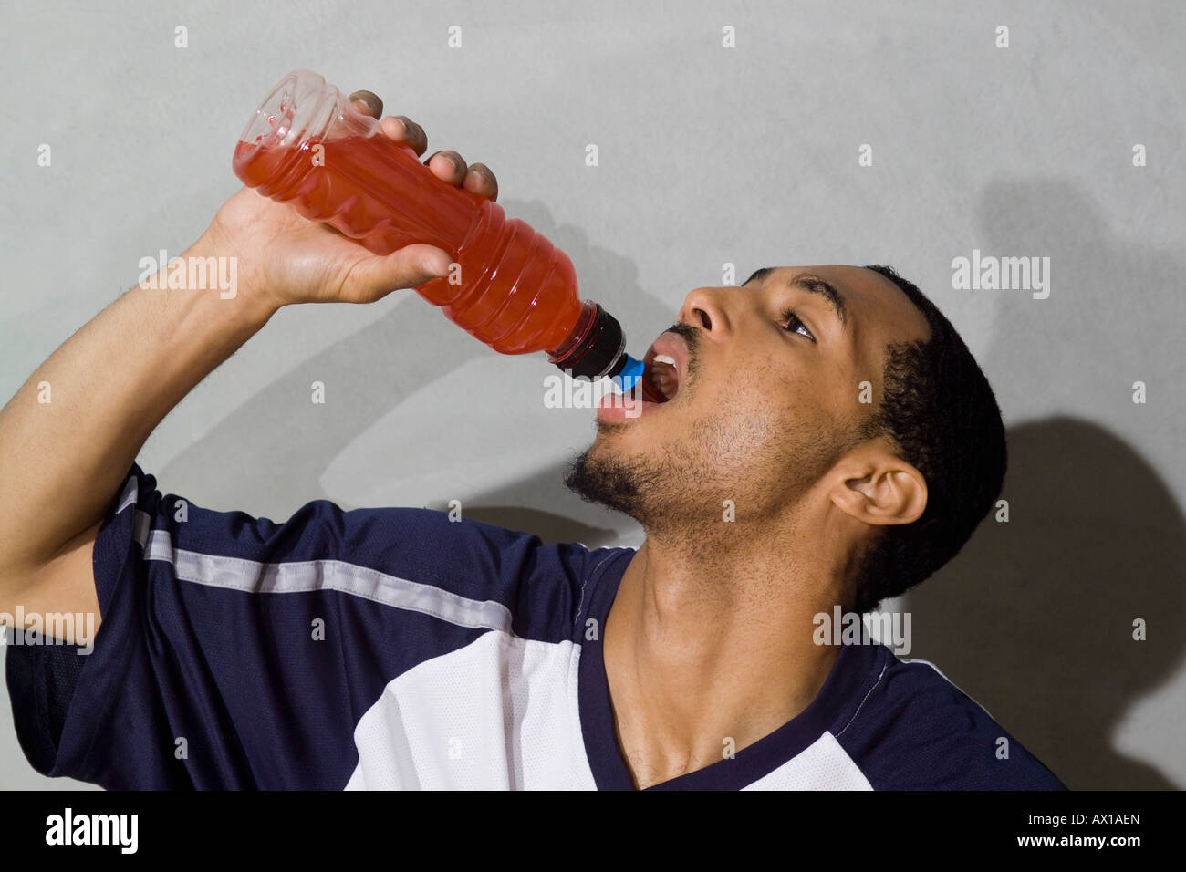 A young man drinking a sports drink Stock Photo - Alamy