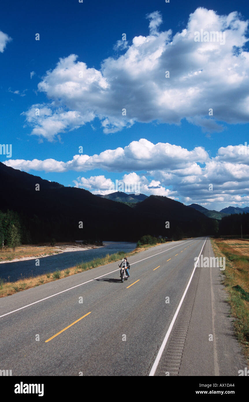 Canada British Columbia near Fernie motorcycle rider on road by Elk River at Morrisey Stock Photo