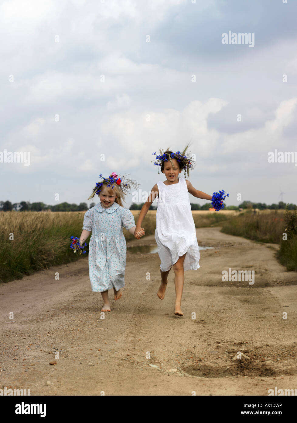 Two young girls running along a country road Stock Photo - Alamy