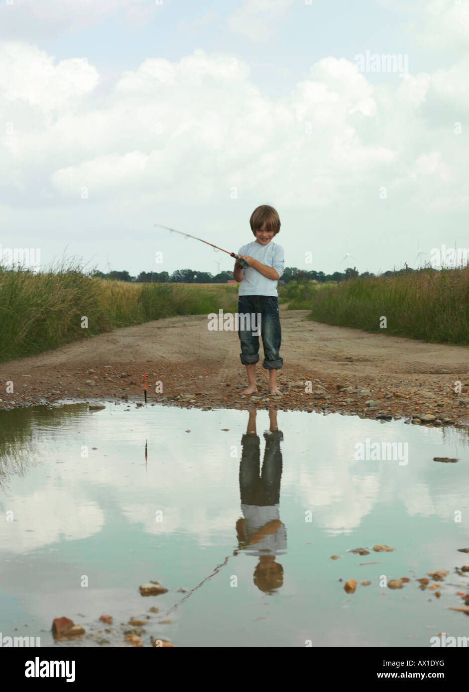A boy fishing in a puddle Stock Photo Alamy