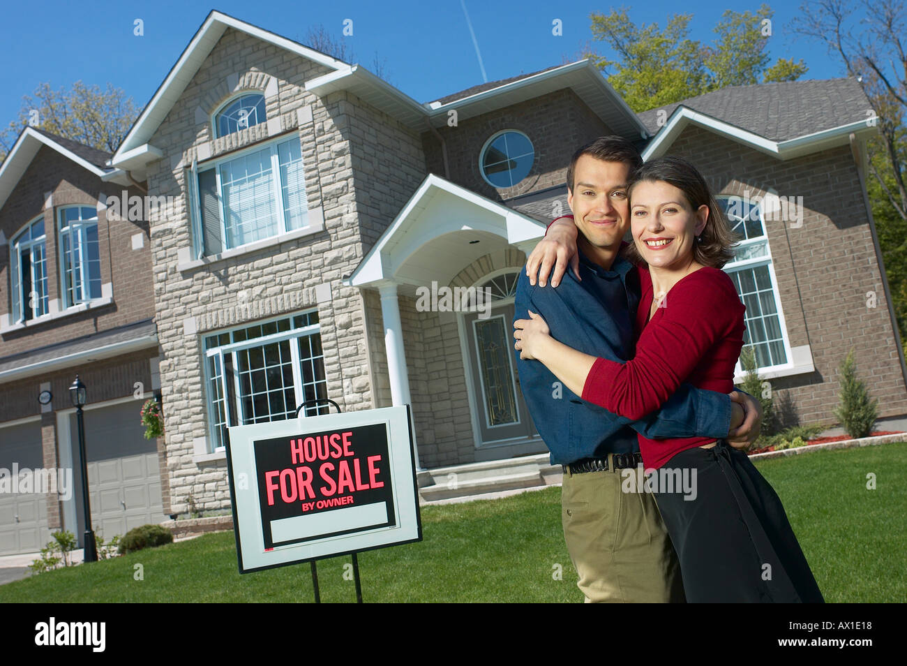 Smiling young couple in front of their new home 2 Stock Photo - Alamy