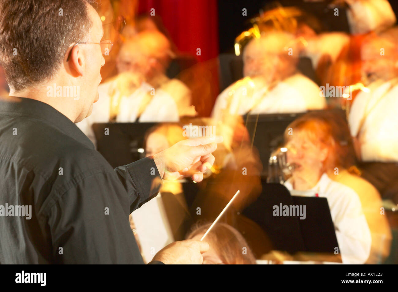 Blur of conductor in front of orchestra Stock Photo