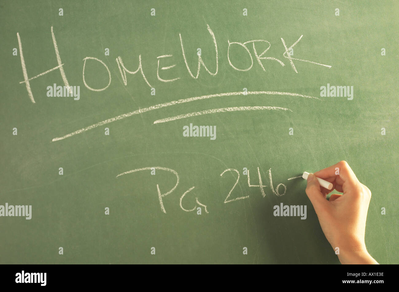 Teacher writing homework on green chalkboard 1 Stock Photo - Alamy