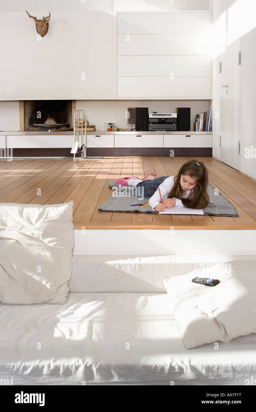 A little girl lying on the floor and drawing Stock Photo - Alamy