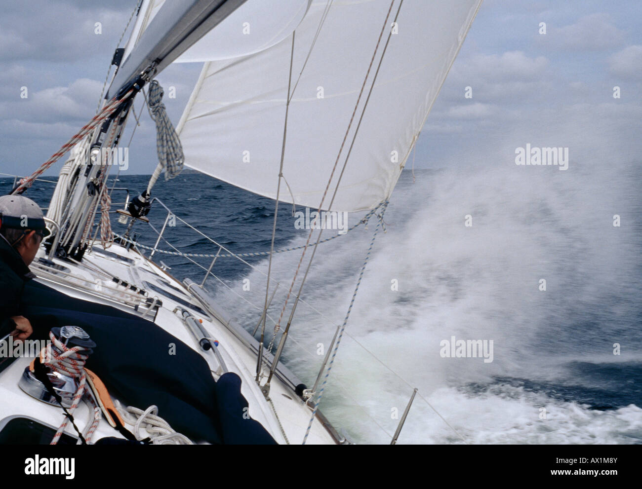 A man steering a yacht in rough weather Stock Photo