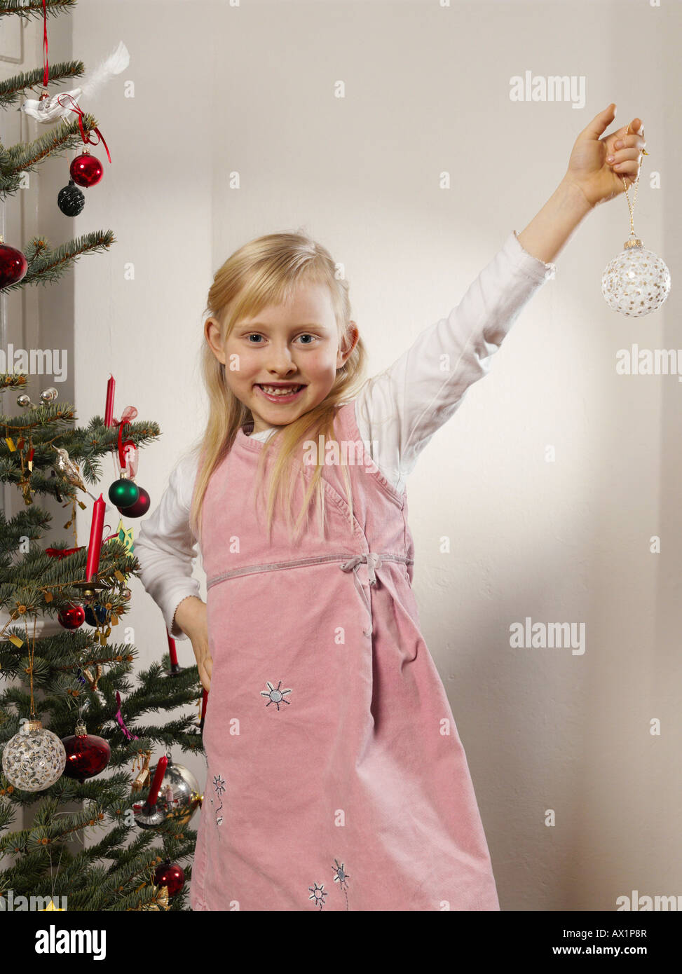 A girl holding a Christmas bauble Stock Photo - Alamy