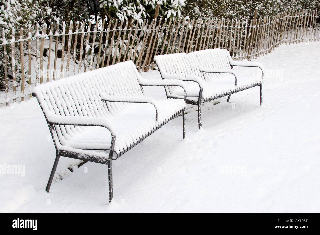 Outdoor park benches in winter, covered in snow Stock Photo