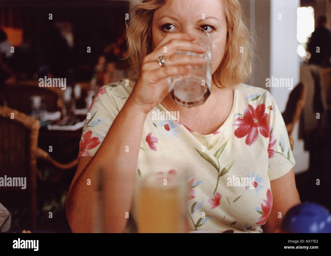 A mature adult woman drinking Stock Photo