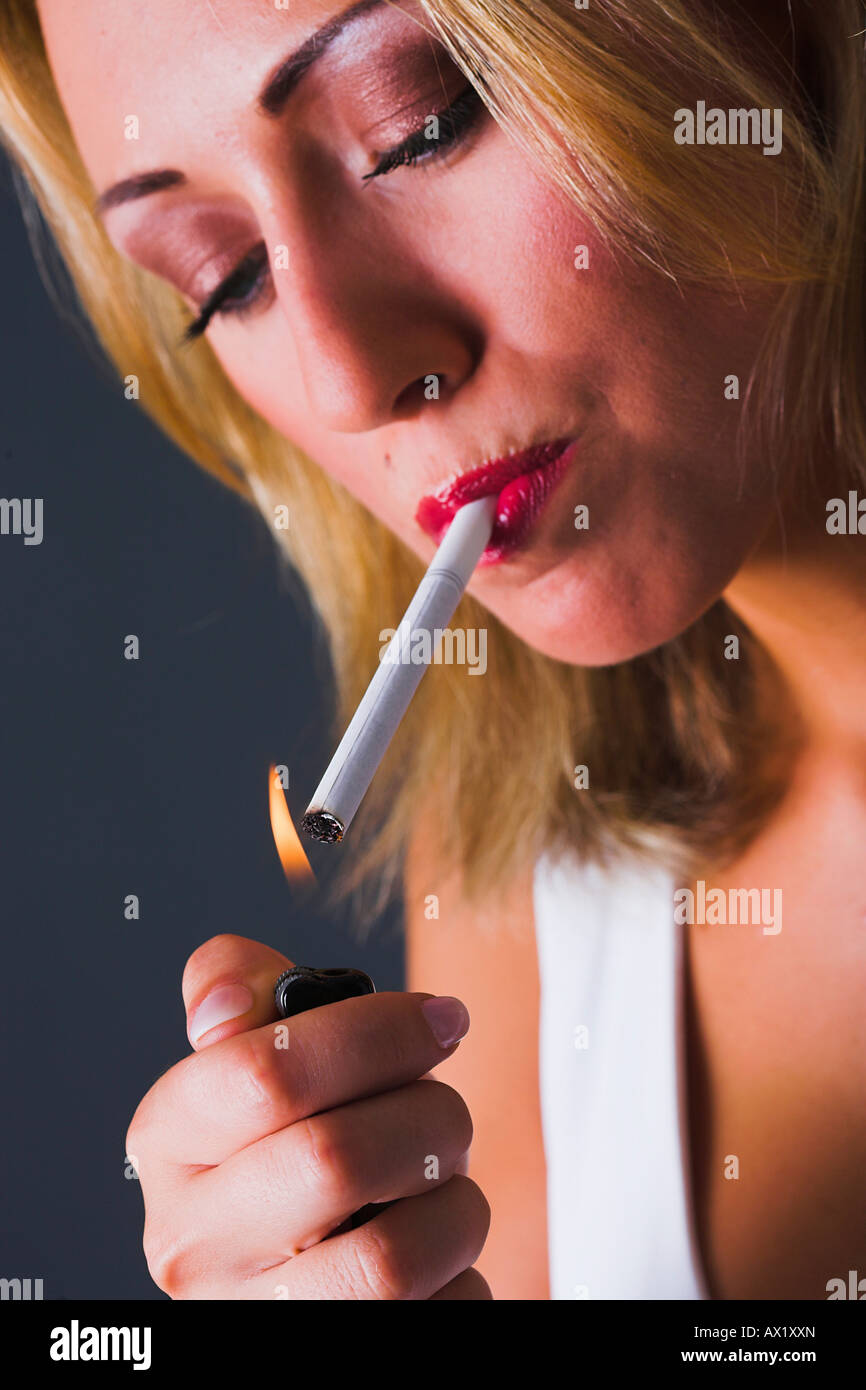 Woman lights a cigarette Stock Photo