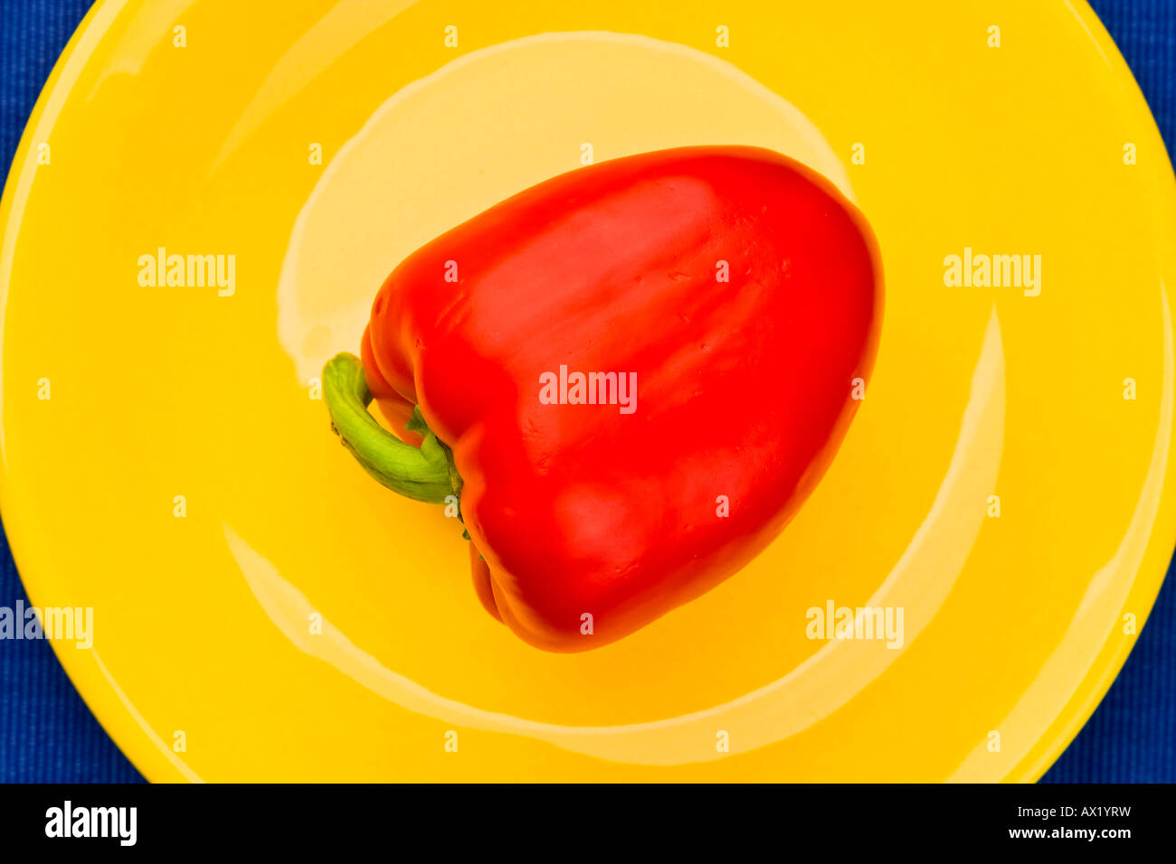 Red pepper (capsicum) on yellow plate Stock Photo