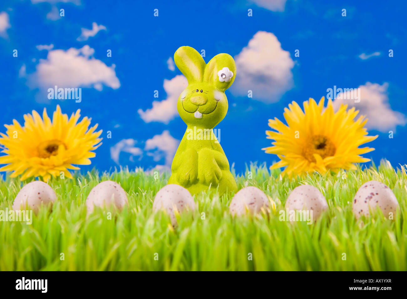Easter bunny on meadow with Easter eggs and flowers in the background Stock Photo