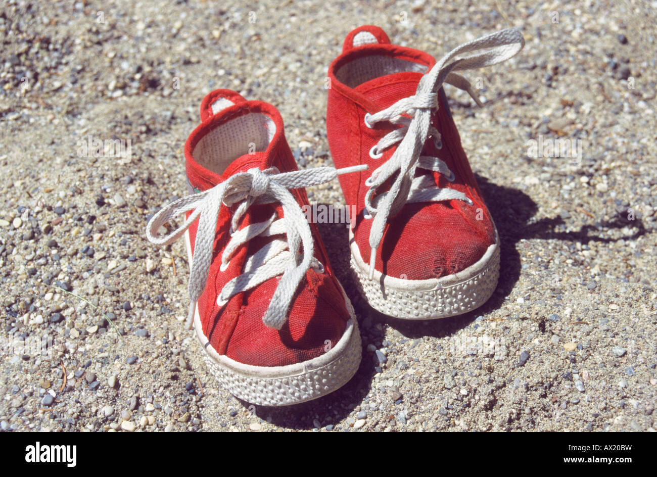 Worn, red kid's shoes in sandbox Stock Photo