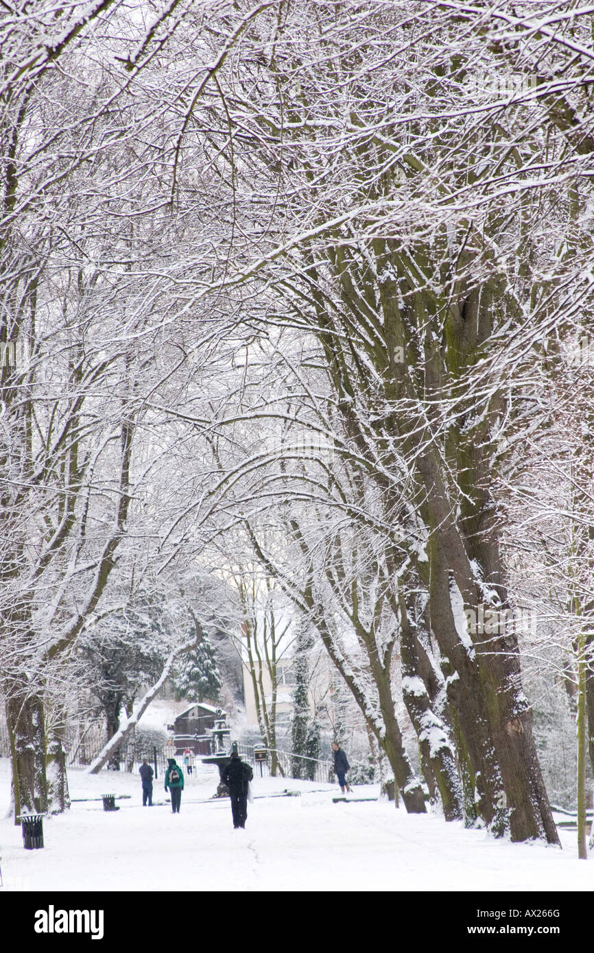 People walking along snow covered pathway in the Arboretum in Lincoln, Lincolnshire Stock Photo