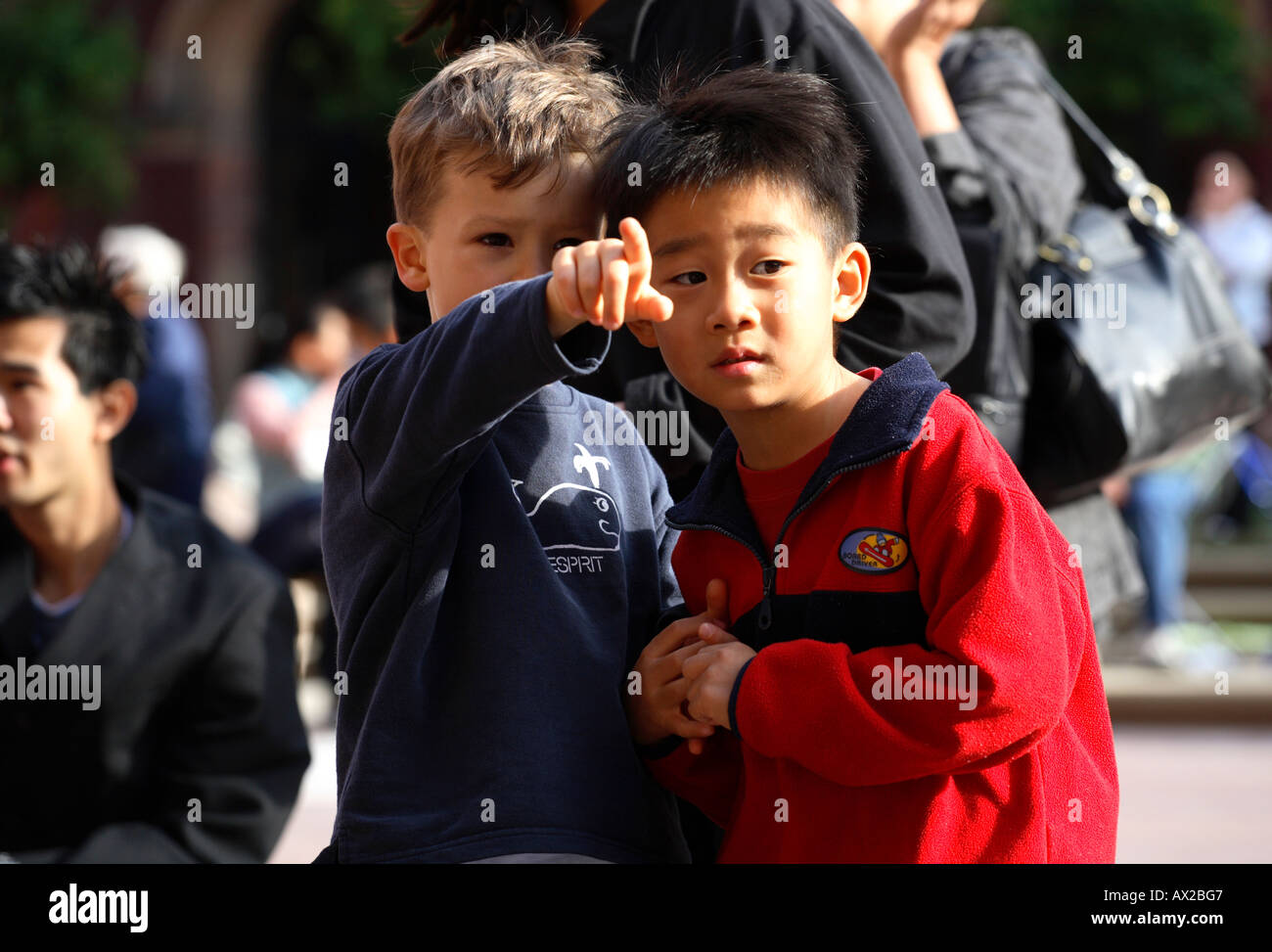 Two young boys - interracial best friends - one white, one Chinese holding hands in the audience at the Mid-Autumn Festival, V&A Museum, October 2006 Stock Photo