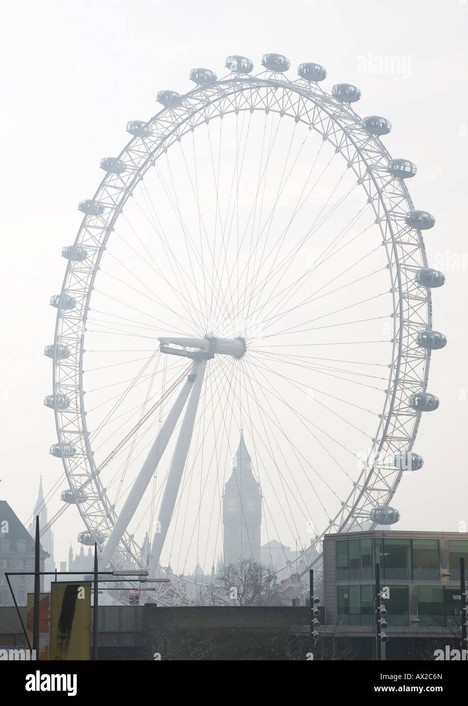 View of the London Eye from the South Bank on Waterloo Bridge looking towards the Houses of Parliament on a hazy winter's day. Stock Photo