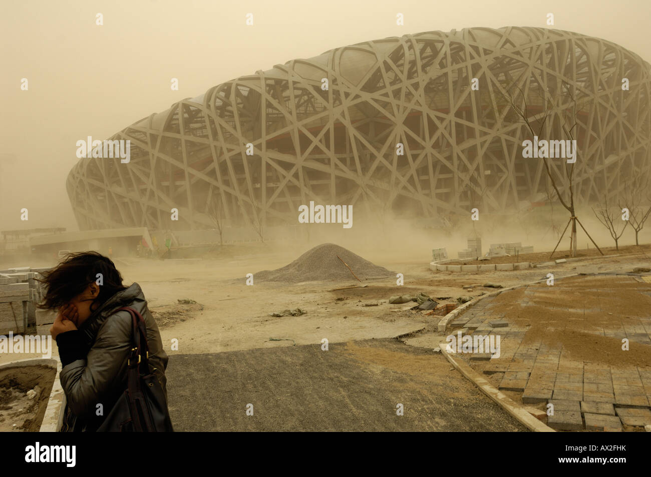 Lady covers her face with hand amid severe sandstorm in construction site of National Stadium for Beijing Olympics.18-Mar-2008 Stock Photo