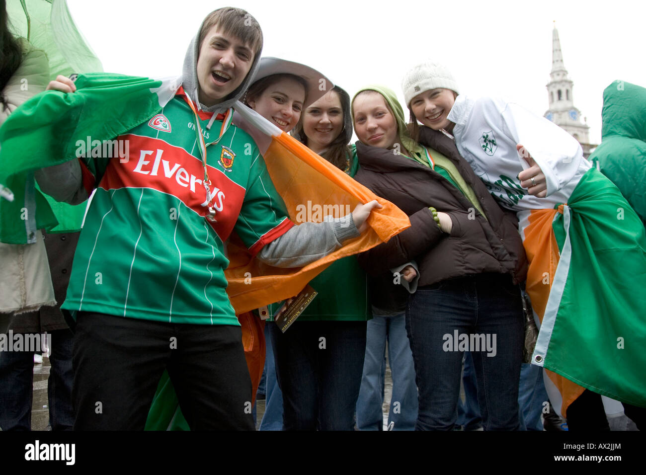 A group of Irish friends posing with a large Irish flag at Trafalgar Square St Patrick s Day Celebrations London 2008 Stock Photo