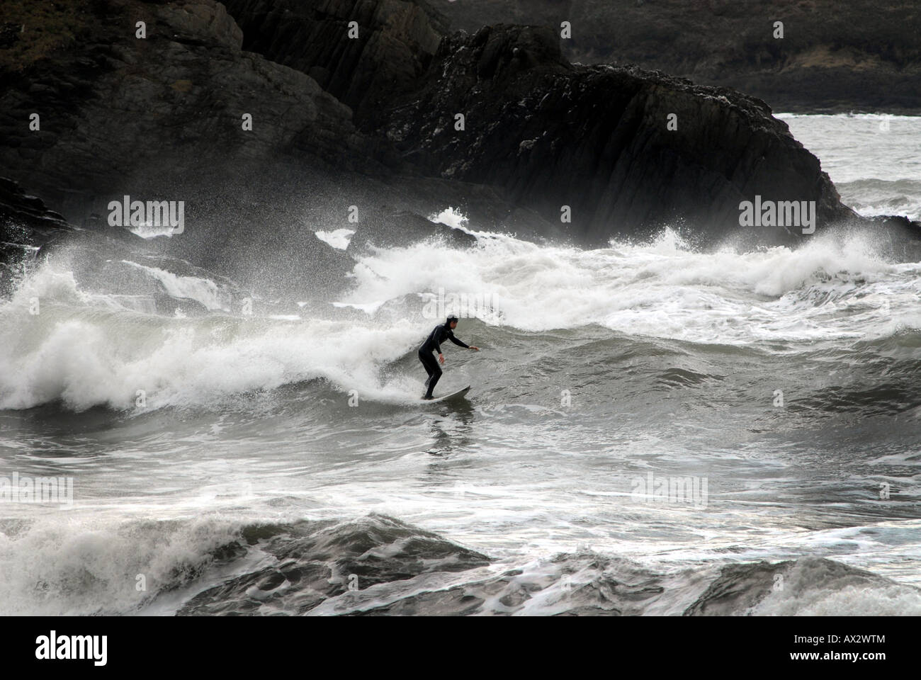 A SURFER NEAR ROCKS IN CHALLABOROUGH BAY,NEAR BIGBURY ON SEA,DEVON,UK. Stock Photo