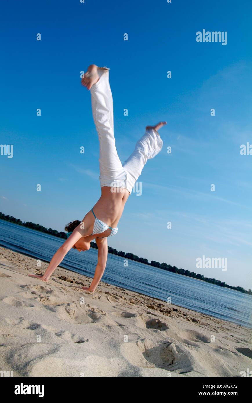 Young woman in motion at the beach, Hamburg, Germany Stock Photo