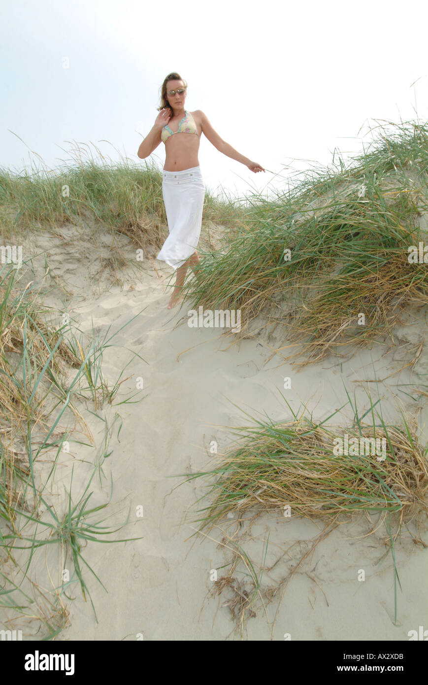 young girl coast grass sands beach sky hot Sommer Sonne Strand Stock Photo