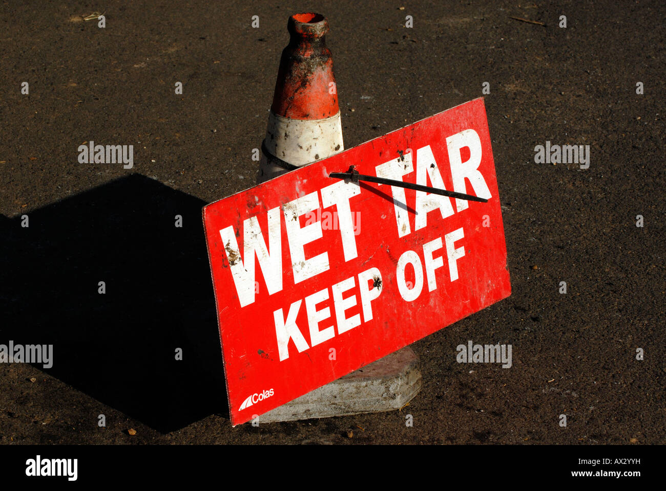 wet tar sign tied to traffic bollard at roadworks Stock Photo Alamy