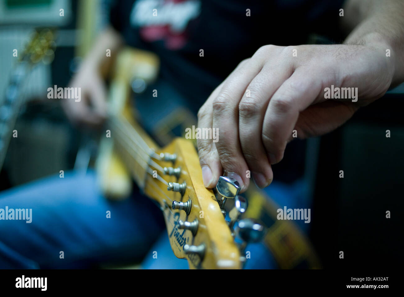 a musician tuning his electric guitar inside a studio Stock Photo Alamy