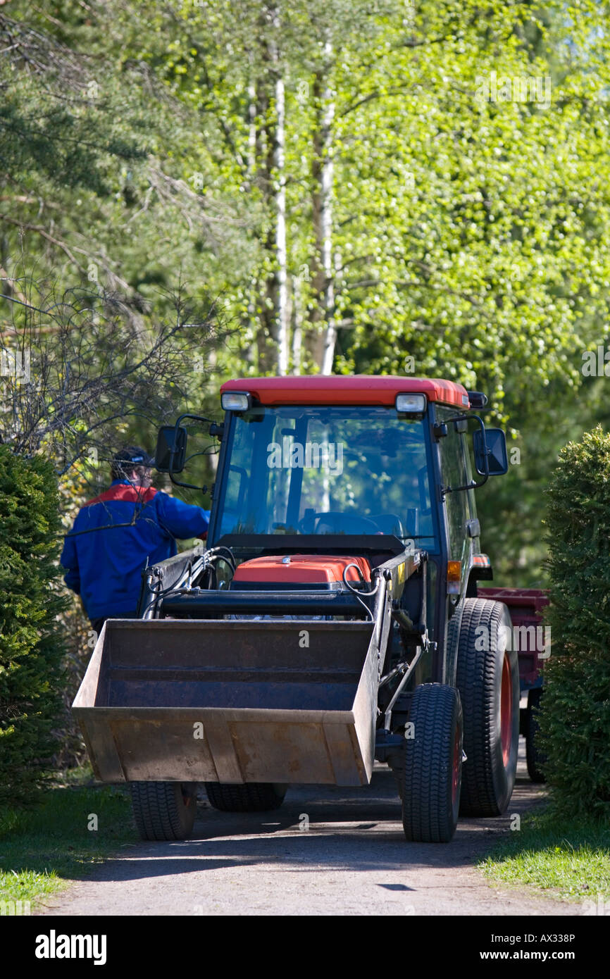 Worker And A Small Red Kubota Garden Tractor Finland Stock Photo