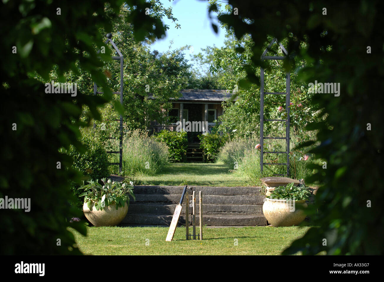 A SET OF STUMPS AND CRICKET BAT IN THE GARDEN AT MANOR FARM SOMERSET BY GARDEN DESIGNER SIMON JOHNSON UK Stock Photo