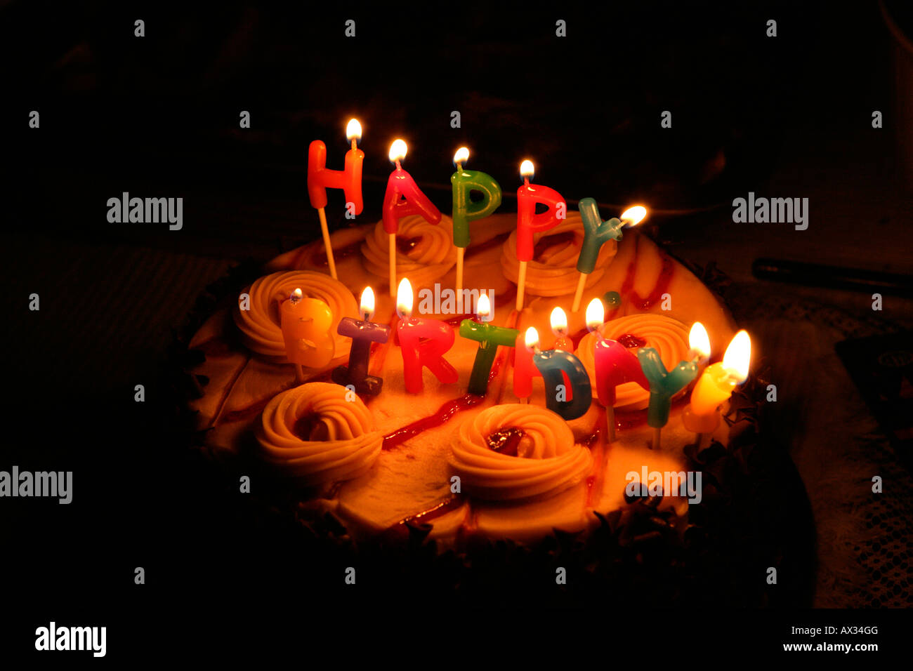 Lighted candles on a birthday cake Stock Photo - Alamy