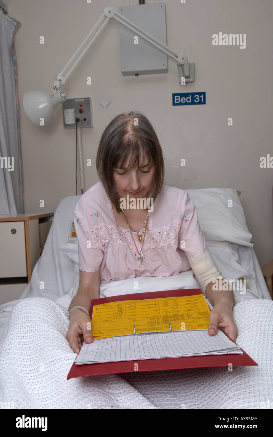 Female patient reading hospital notes Stock Photo Alamy